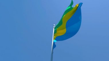 Gabon 'un ulusal bayrağı mavi gökyüzüne karşı rüzgarda dalgalanıyor.