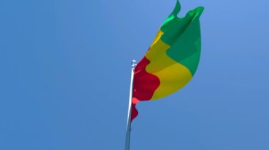 Gine 'nin ulusal bayrağı mavi gökyüzüne karşı rüzgarda dalgalanıyor.