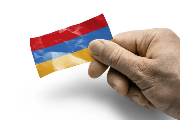 Hand som innehar ett kort med en nationell flagga Armenien — Stockfoto