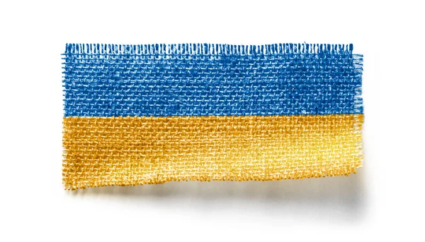 Прапор України на шматку тканини на білому тлі. — стокове фото