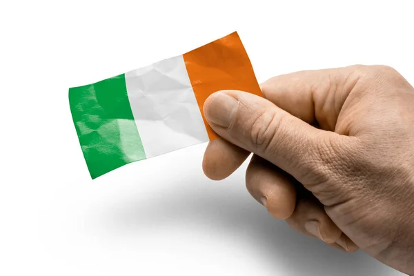 Mano sosteniendo una tarjeta con una bandera nacional Irlanda — Foto de Stock