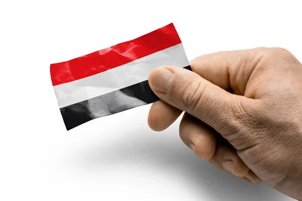 Mano sosteniendo una tarjeta con una bandera nacional el Yemen — Foto de Stock