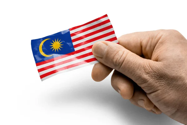 Ręcznie trzymając kartę z flagą narodową Malezji — Zdjęcie stockowe