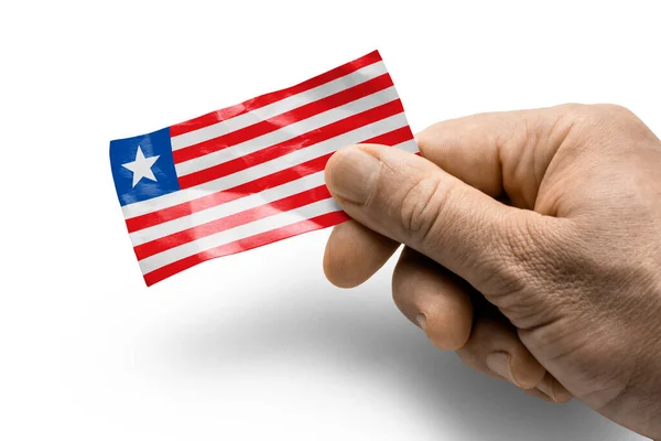Рука тримає картку з національним прапором Ліберія. — стокове фото