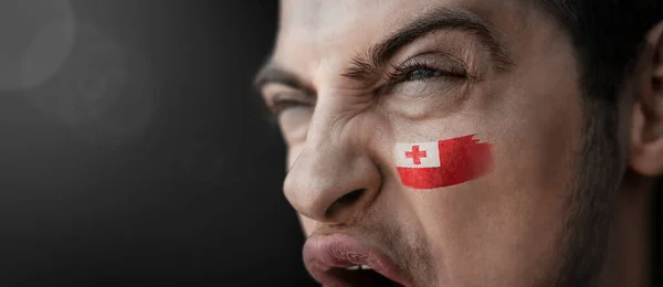 Un hombre gritando con la imagen de la bandera nacional de Tonga en su cara —  Fotos de Stock