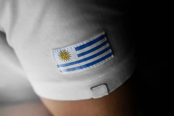 Parche de la bandera nacional del Uruguay en una camiseta blanca — Foto de Stock