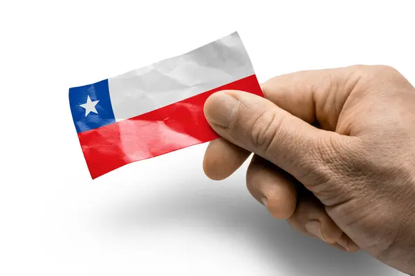 Mano sosteniendo una tarjeta con bandera nacional el Chile —  Fotos de Stock