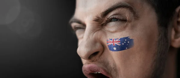 Un hombre gritando con la imagen de la bandera nacional de Australia en su cara — Foto de Stock