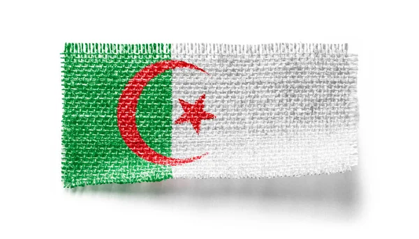 Прапор Алжиру на шматку тканини на білому тлі. — стокове фото