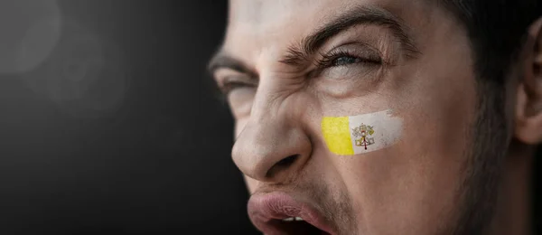 En skrikande man med Vatikanens nationalflagga i ansiktet — Stockfoto