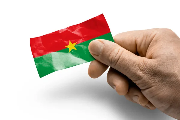 Mano sosteniendo una tarjeta con una bandera nacional la Burkina Faso — Foto de Stock