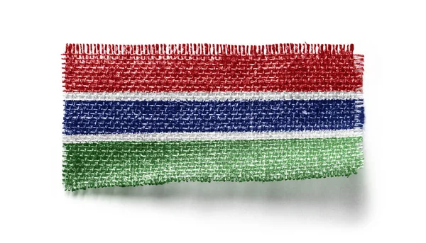 Gambia flagga på ett tygstycke på en vit bakgrund — Stockfoto