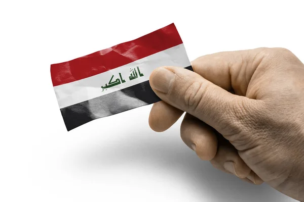 Tangan memegang kartu dengan bendera nasional Irak — Stok Foto