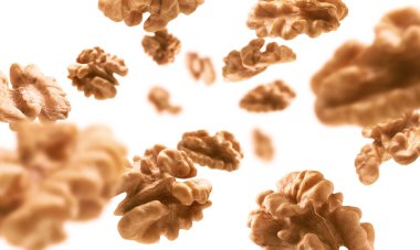 Kabuktan soyulmuş, ceviz çekirdekleri beyaz bir zeminde uçar.