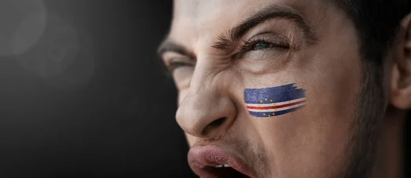 케이프베르데 국기가 그의 얼굴에 붙어 있는 모습으로 소리치는 남자 — 스톡 사진