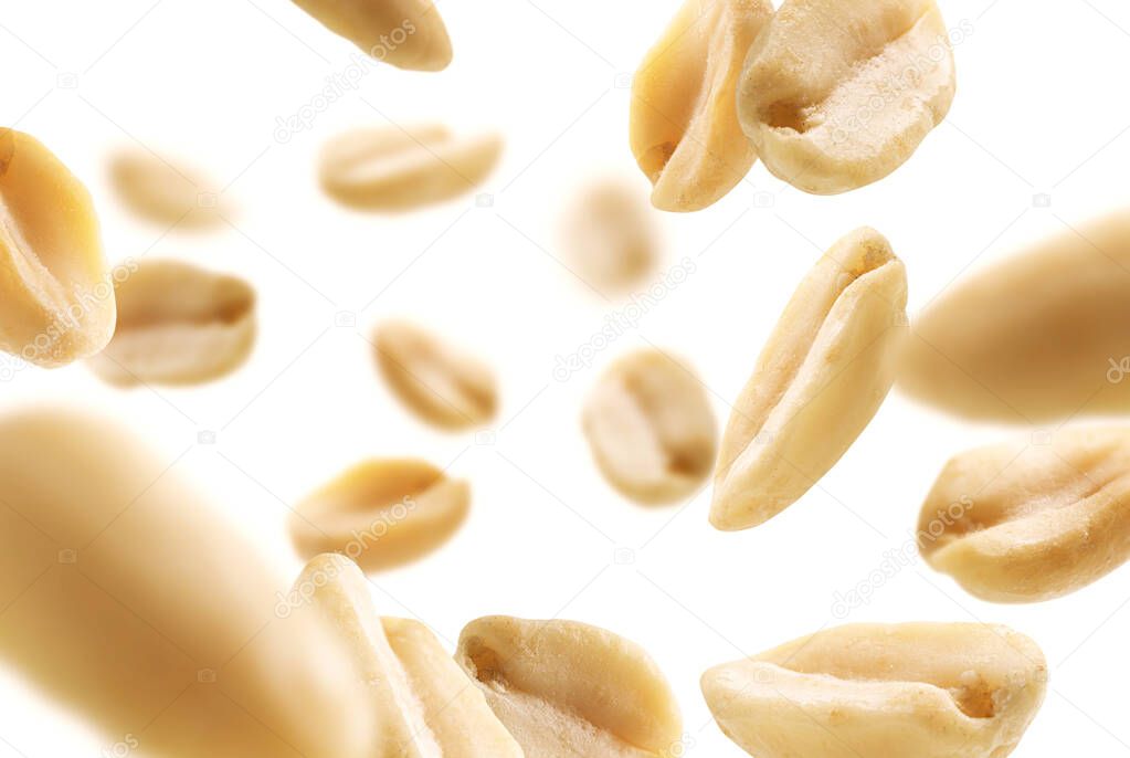 Peeled peanuts levitate on a white background