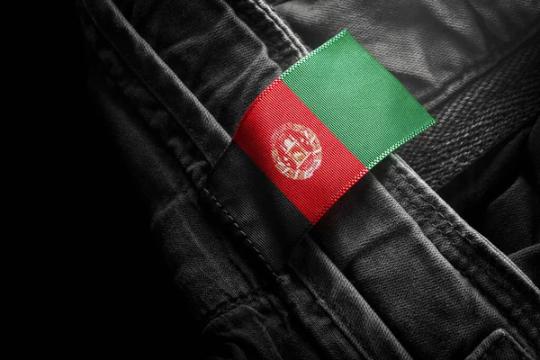 Etiqueta en la ropa oscura en forma de la bandera de Afganistán —  Fotos de Stock