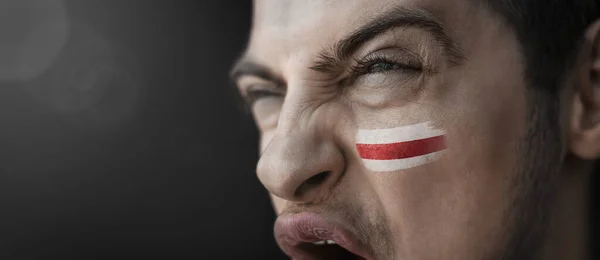 A screaming man with the image of the Belarus national flag on his face — Stock Photo, Image