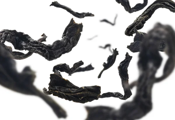 Dried black tea close up levitating on white background — Stock Photo, Image