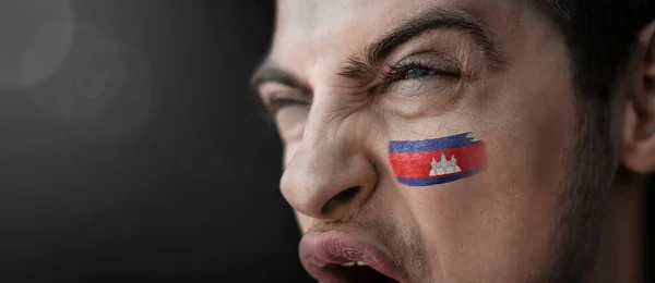 Un hombre gritando con la imagen de la bandera nacional de Camboya en su cara —  Fotos de Stock