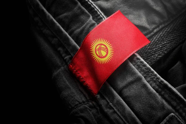Tag auf dunkler Kleidung in Form der Flagge der Kirgisen — Stockfoto