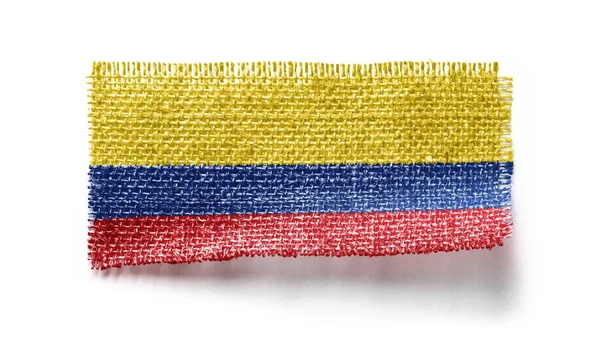 Colombia flagga på ett tygstycke på en vit bakgrund — Stockfoto