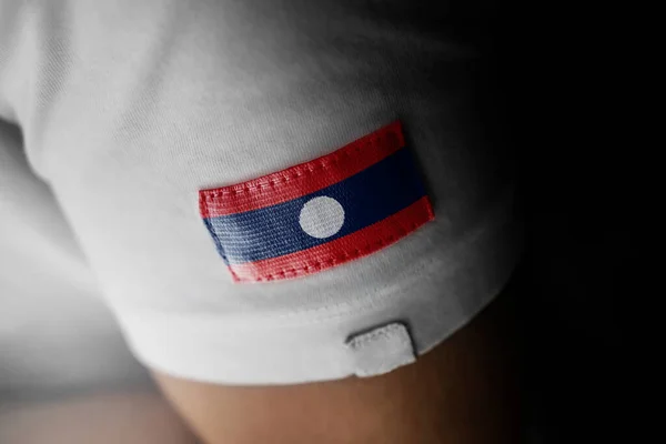 Aufnäher der laotischen Nationalflagge auf einem weißen T-Shirt — Stockfoto