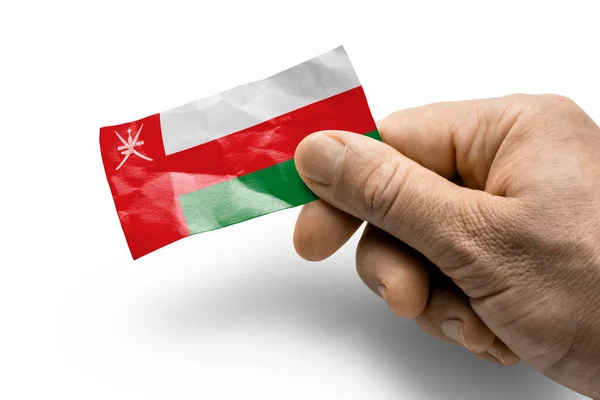 Main tenant une carte avec un drapeau national l'Oman — Photo
