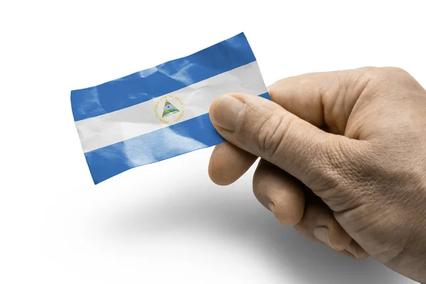 Mano sosteniendo una carta con bandera nacional Nicaragua — Foto de Stock