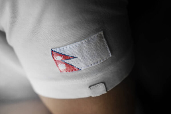 Patch of the national flag of the Nepal on a white t-shirt