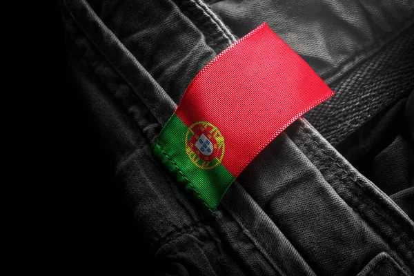 Štítek na tmavém oblečení v podobě vlajky Portugalska — Stock fotografie