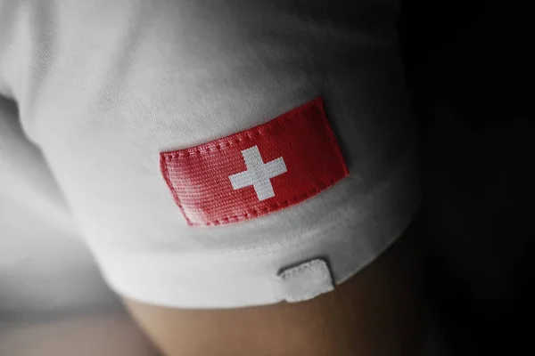 Parche de la bandera nacional de Suiza en una camiseta blanca — Foto de Stock