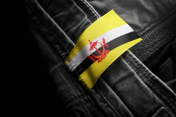 Tag on dark clothing in the form of the flag of the Brunei — Stock Photo, Image