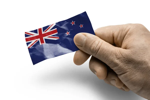 Mano sosteniendo una tarjeta con una bandera nacional de Nueva Zelanda —  Fotos de Stock