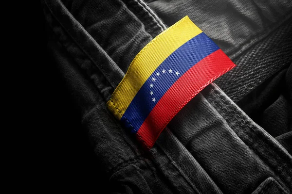 Štítek na tmavém oblečení v podobě vlajky Venezuely — Stock fotografie