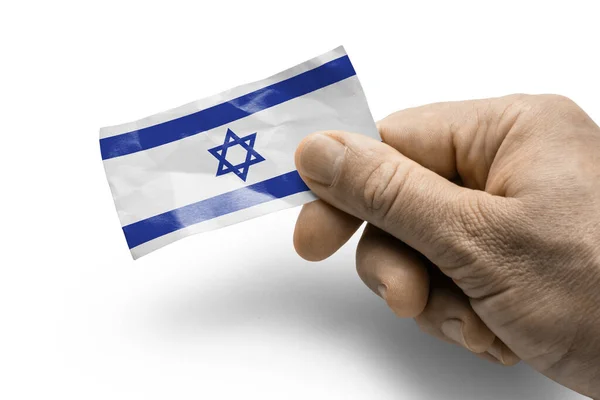 Hand som innehar ett kort med nationell flagga Israel — Stockfoto