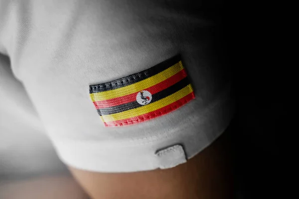 Patch av Ugandas nationella flagga på en vit t-shirt — Stockfoto