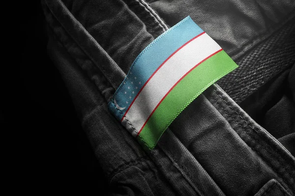 Метка на темной одежде в виде флага Узбекистана — стоковое фото