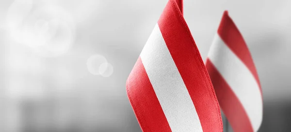 Невеликі національні прапори Австрії на світлому нечіткому тлі — стокове фото