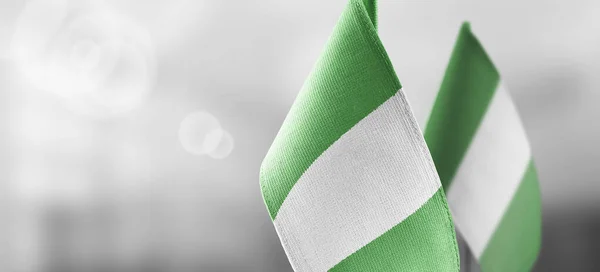 Kis nemzeti zászlók a Nigéria egy kis homályos háttér — Stock Fotó