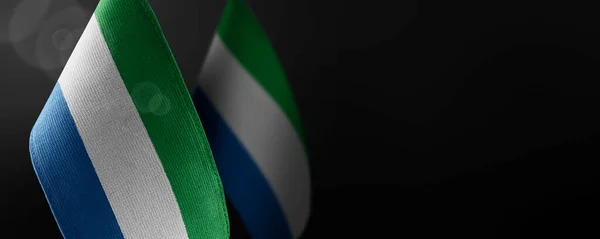 Small national flags of the Sierra Leone on a dark background — Stock Photo, Image