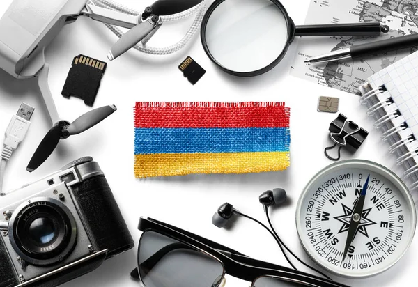 Bandera de Armenia y accesorios de viaje sobre fondo blanco. — Foto de Stock