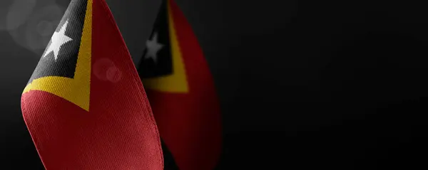 Pequeñas banderas nacionales de Timor Oriental sobre un fondo oscuro — Foto de Stock