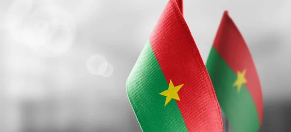 Pequeñas banderas nacionales de Burkina Faso sobre un fondo claro y borroso — Foto de Stock