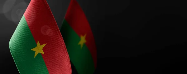 Pequeñas banderas nacionales de Burkina Faso sobre un fondo oscuro — Foto de Stock