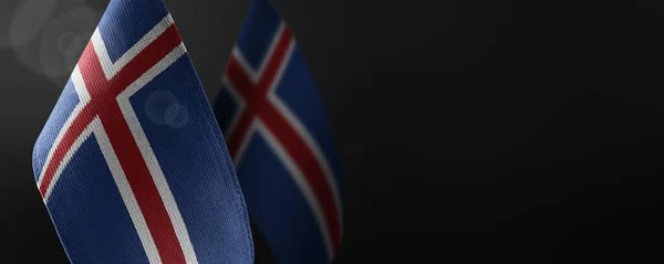Pequenas bandeiras nacionais da Islândia num fundo escuro — Fotografia de Stock