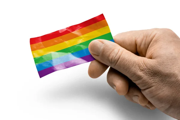 Mão segurando um cartão com uma bandeira nacional o lgbt — Fotografia de Stock