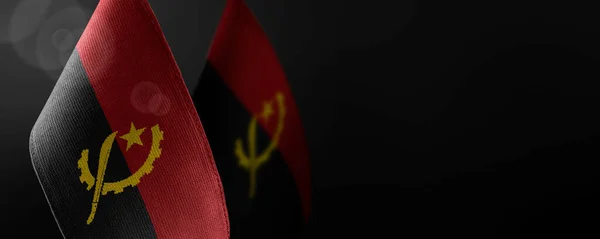 Маленькие национальные флаги Анголы на тёмном фоне — стоковое фото