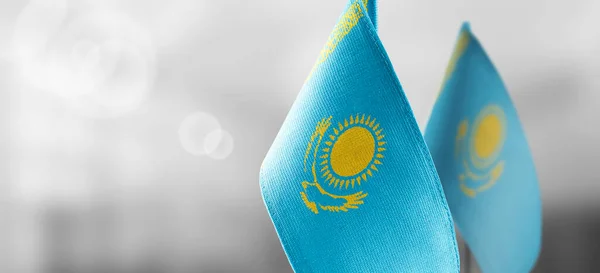 Kazahsztán kis nemzeti zászlói homályos háttérrel — Stock Fotó