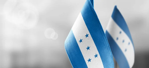 Small national flags of the Honduras on a light blurry background — Stock Photo, Image